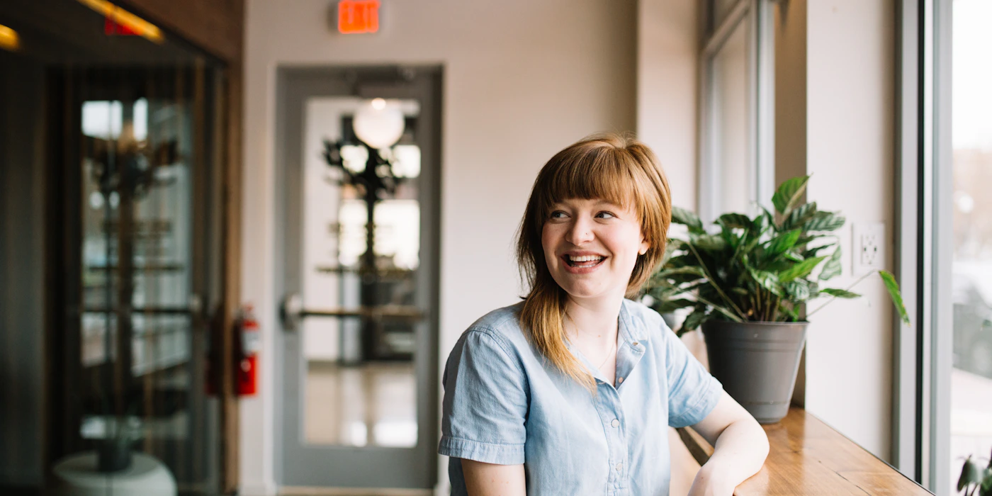 Person sitting thoughtfully by a window in warm light