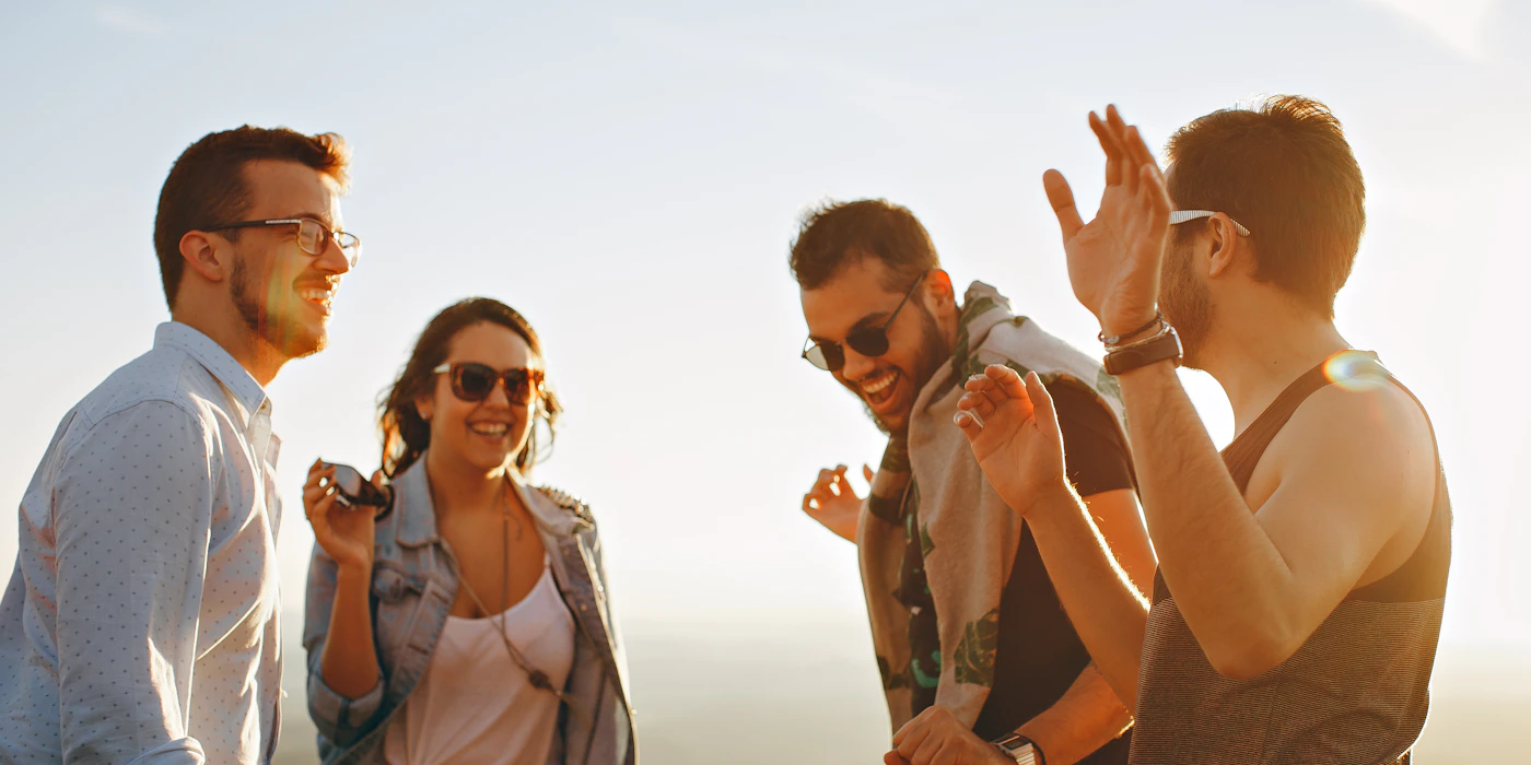 A group of friends laughing together outdoors — the easy, social energy a big college city runs on